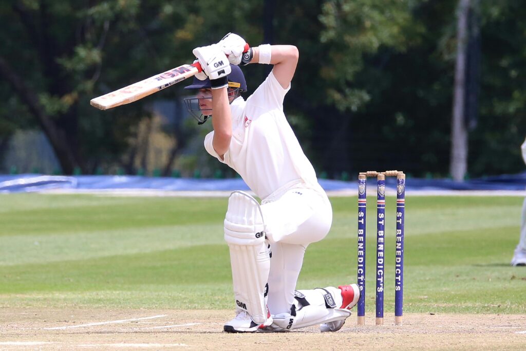 pexels-photo-3800517-3800517 Cricketer in action performing a sweep shot on a sunny outdoor pitch.